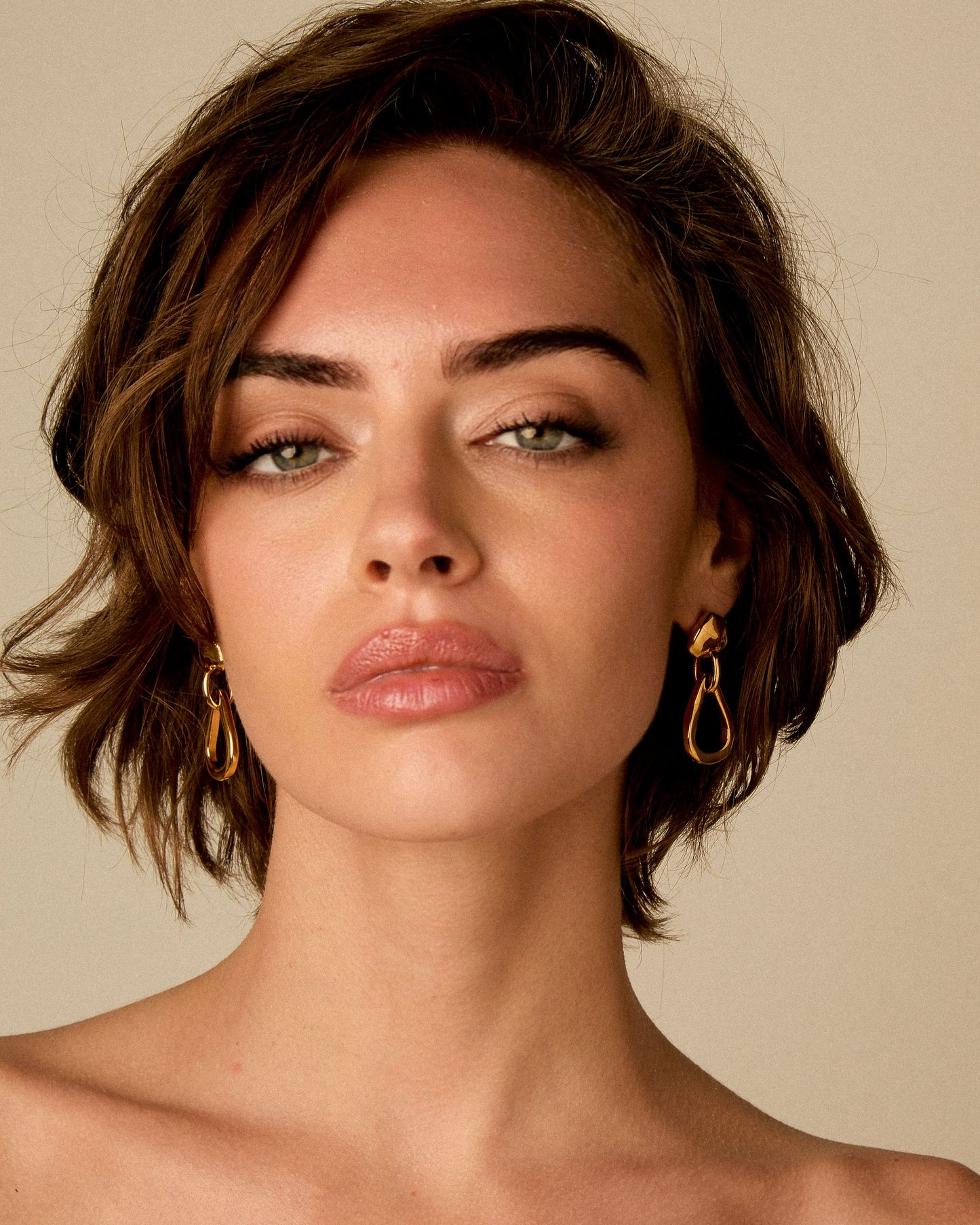 
                  
                    Model wearing small teardrop earrings in 24k gold by Vidda Jewelry.
                  
                