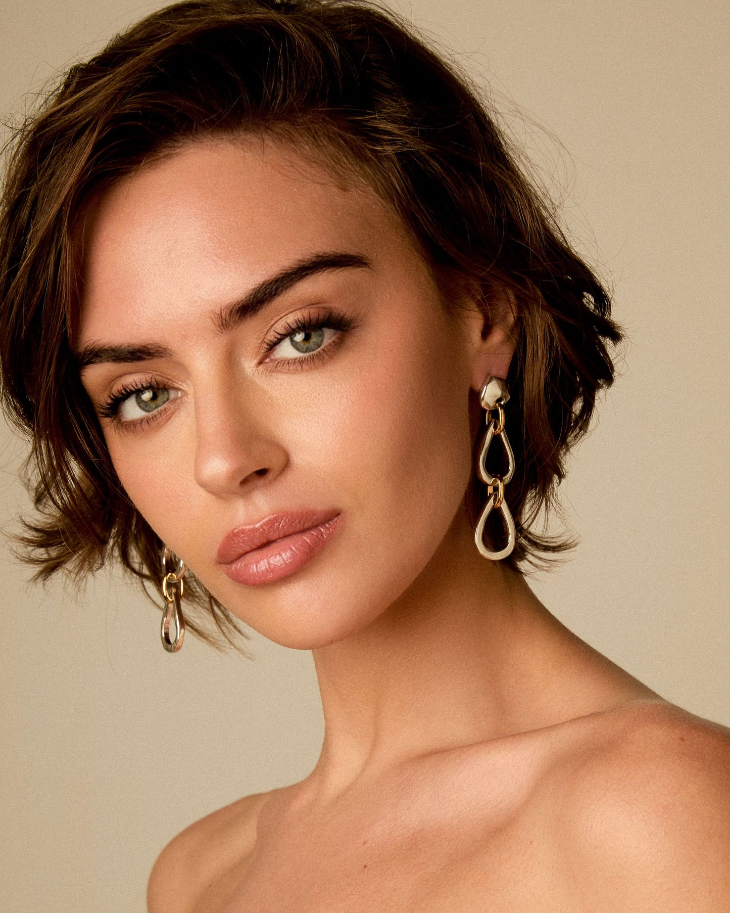 Model wearing long link earrings in mixed 24k gold and sterling silver by Vidda Jewelry.