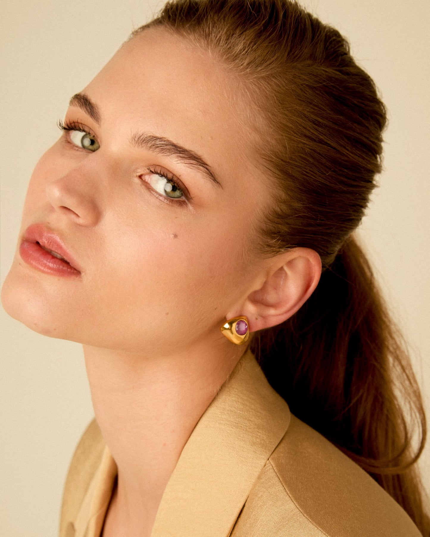 Model wearing elegant triangle earrings with crystal highlighting the ear