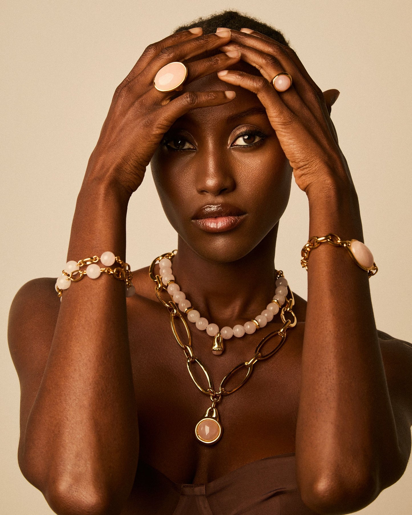 Modelo luciendo collar piedras naturales de dise������o exclusivo con cuentas redondas y cadena dorada, acompa������ado de pulseras y anillos a juego de Vidda Jewelry.