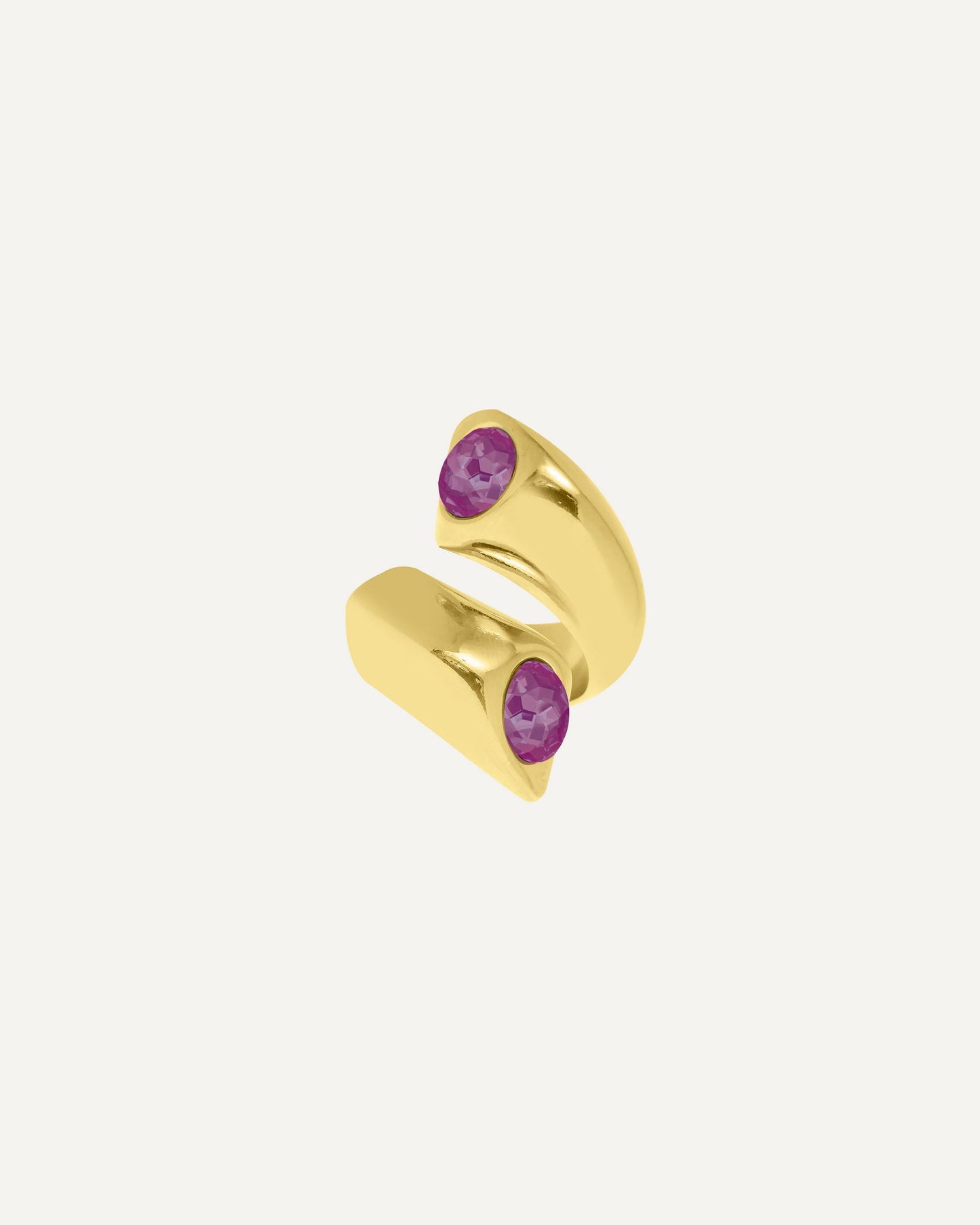 Close-up of a chunky 24K gold plated open ring with two vibrant fuchsia Swarovski crystals on a clean studio background, showcasing its design and details.